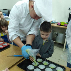 Przedszkolaki podczas warsztatów przygotowują ciastka pod okiem kucharzy